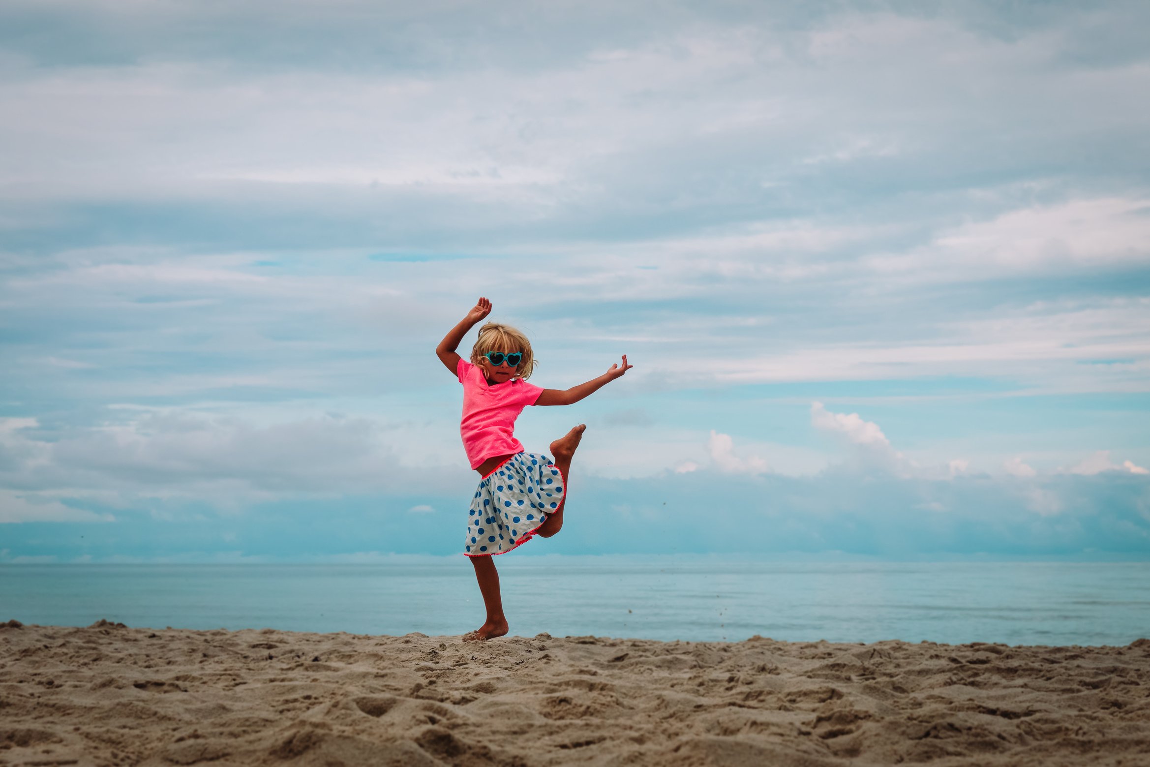 cute happy girl dance, child play at summer beach